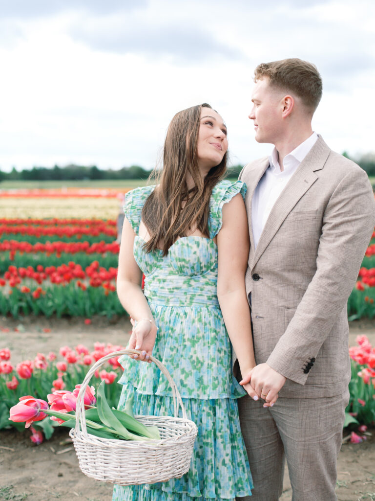 Anne & Elijah walking in the tulip fields in full Bloom at Burnside Farms
