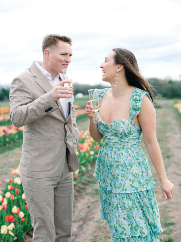 Anne & Elijah sipping champagne in the tulip fields in full Bloom at Burnside Farms