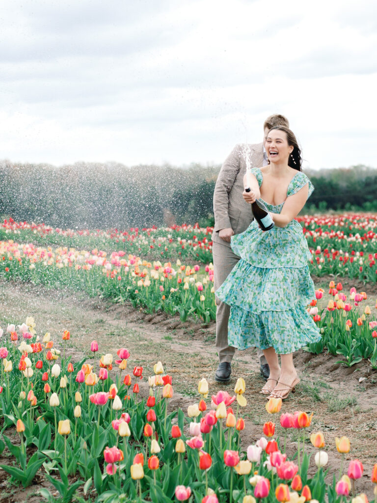 Anne & Elijah spraying champagne in the tulip fields in full Bloom at Burnside Farms