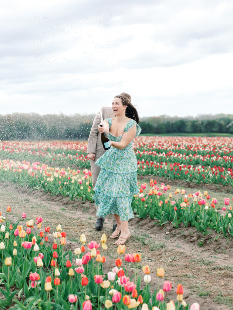 Anne & Elijah spraying champagne in the tulip fields in full Bloom at Burnside Farms